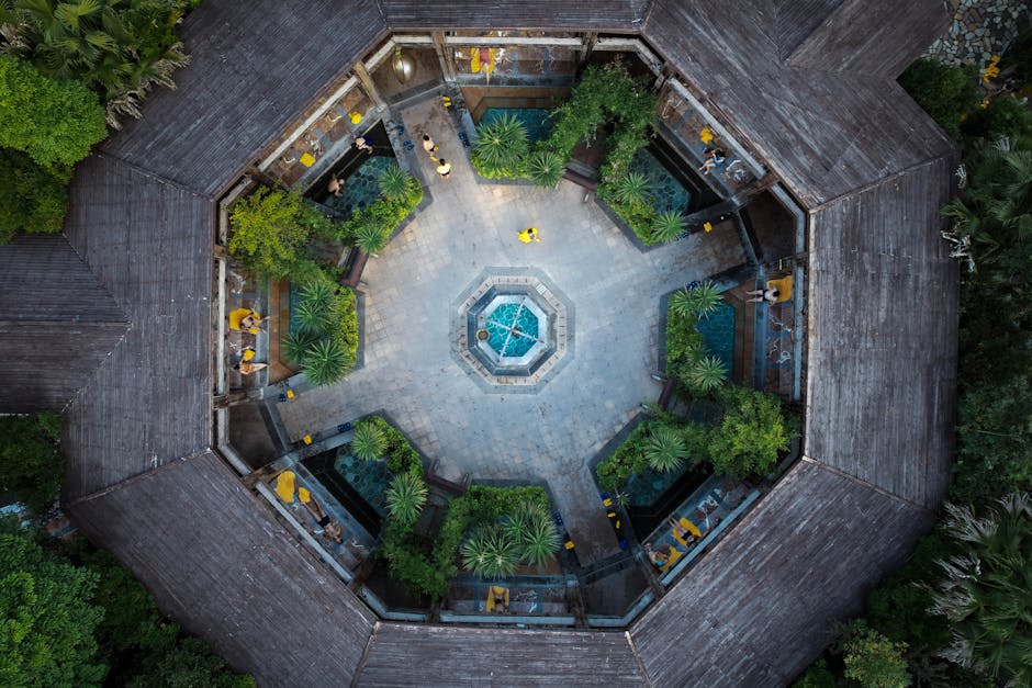 Stunning aerial view of a geometric courtyard featuring a central fountain and lush greenery, an urban oasis.